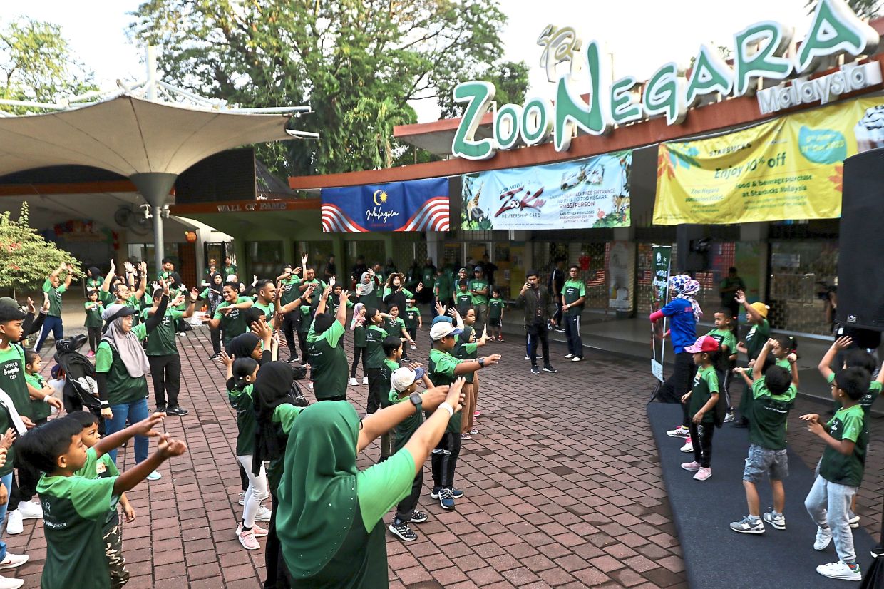 Children and adults enjoying an activity for World Orangutan Day.