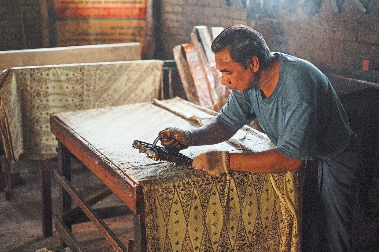 The Batik Maker: Fuad has been making batik for the last five years in Kuala Terengganu. While there are numerous methods of making batik, he specialises in block printing. Photo: Lim Kim Boon 