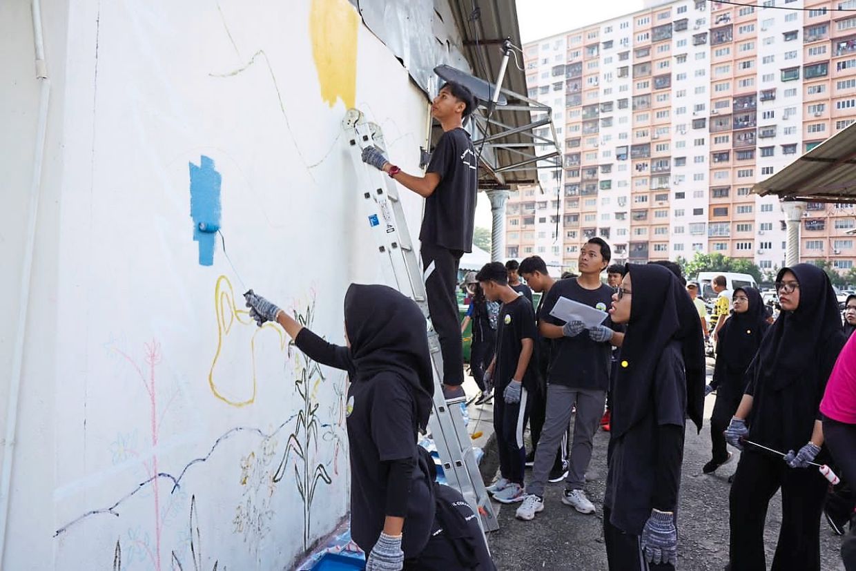 Volunteers from Azmida Technical College painting a mural.