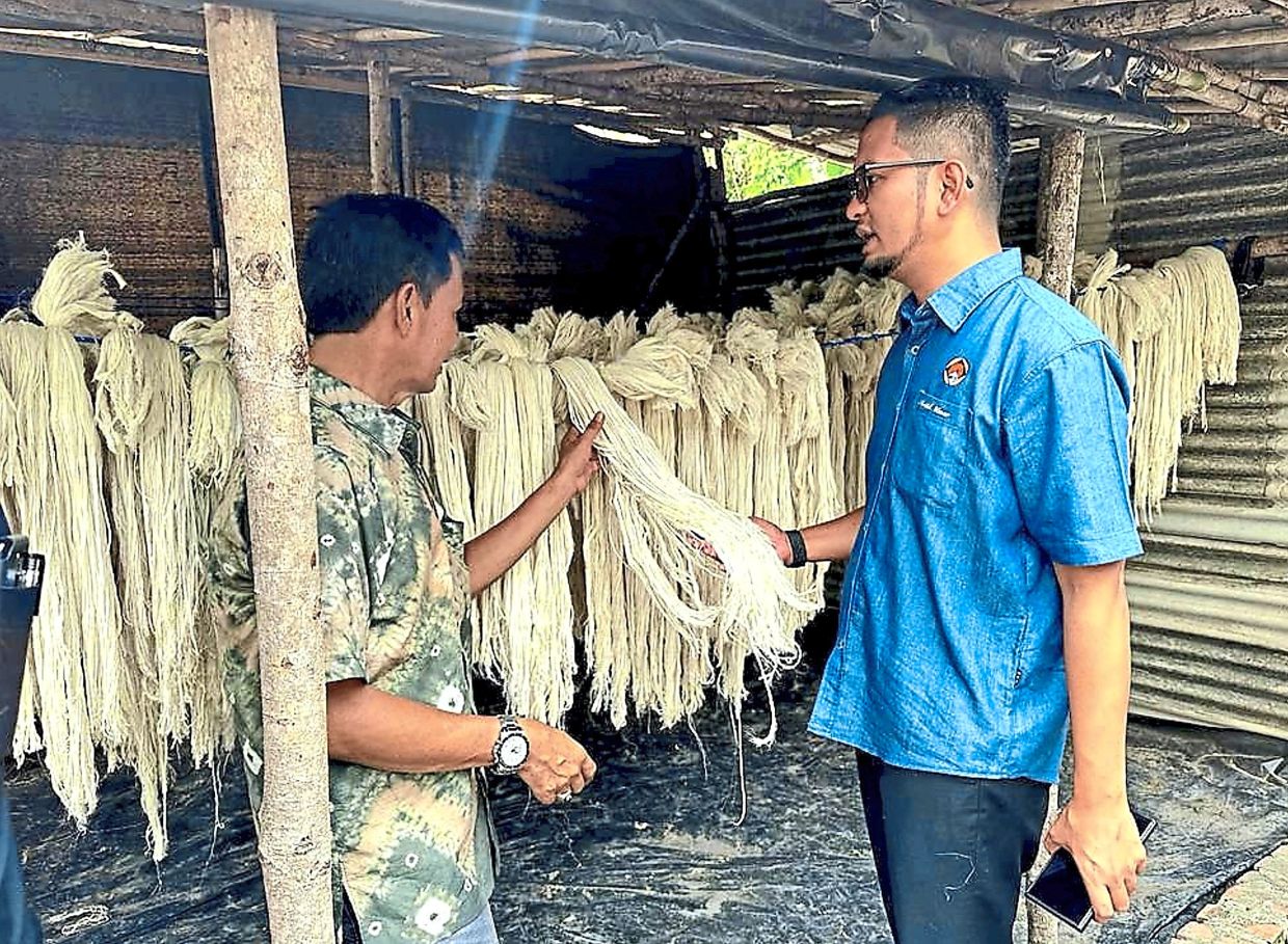 Sheikh Umar (right) visiting a downstream facility, in south Sumatera, Indonesia, which processes threads from pineapples.