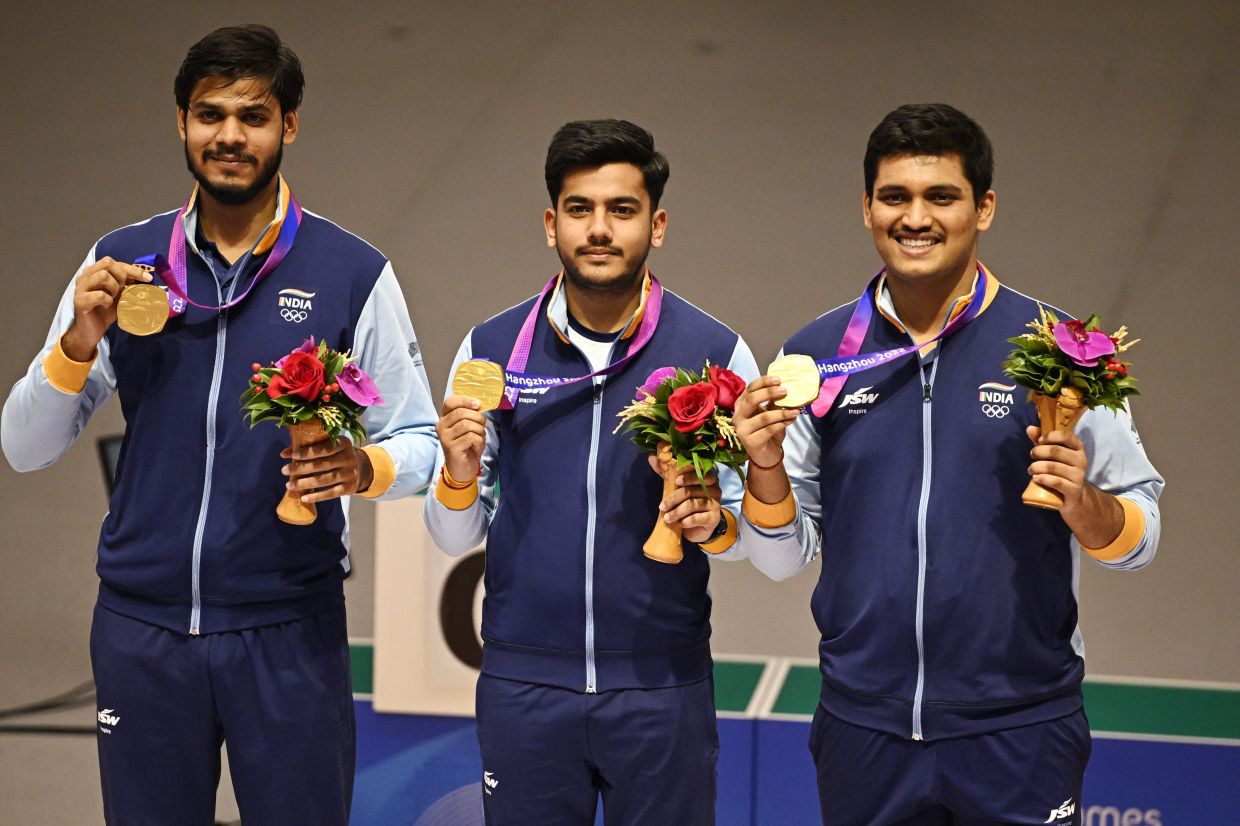 Gold medallist India's Divyansh Singh Panwar, Aishwary Pratap Singh Tomar and Rudrankksh Patil celebrate on the podium after winning the men's 10m air rifle team final in a new world record mark at the Fuyang Yinhu Sports Centre, Hangzhou, Chinaon Monday (Sept 25, 2023). - Reuters