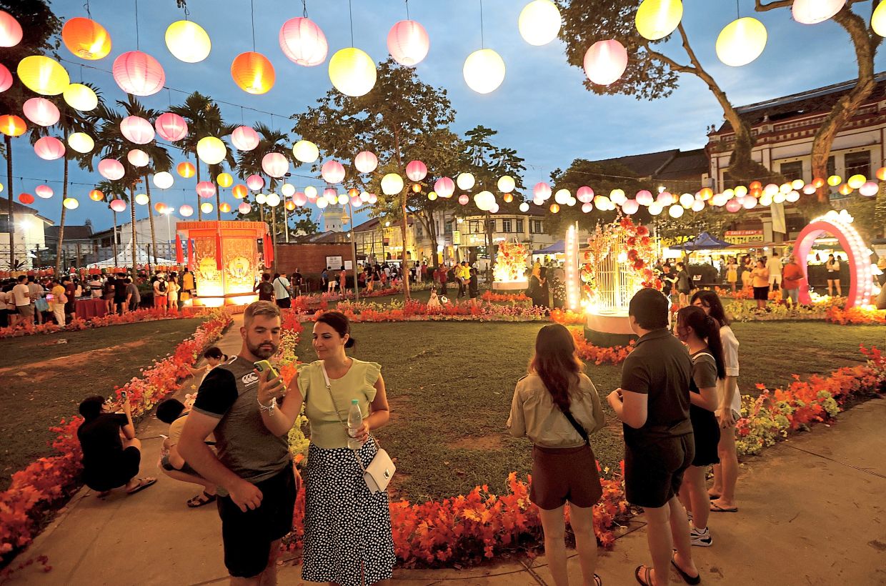 Visitors taking photos at Armenian Park which is illuminated with lanterns.