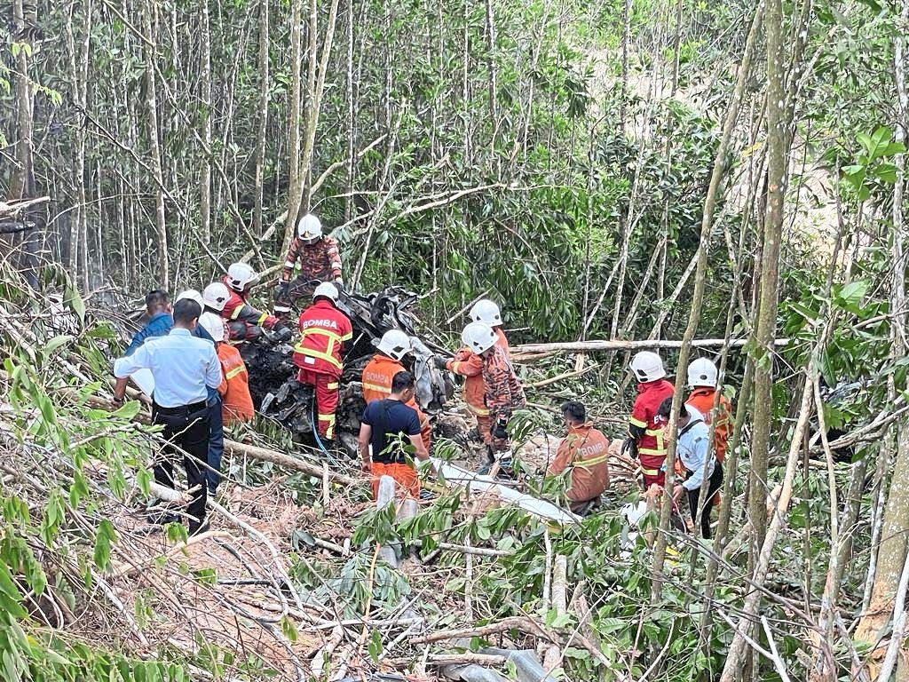 Gruesome task: Rescue personnel extricating the driver’s remains.