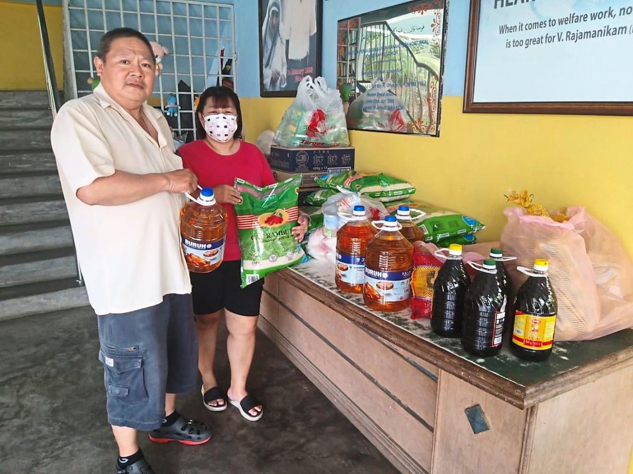 Couple Yong Yew Kim (left) and Chong Hong Kin donating sundry items to Johor Baru Handicapped and Mentally Disabled Children’s Association.