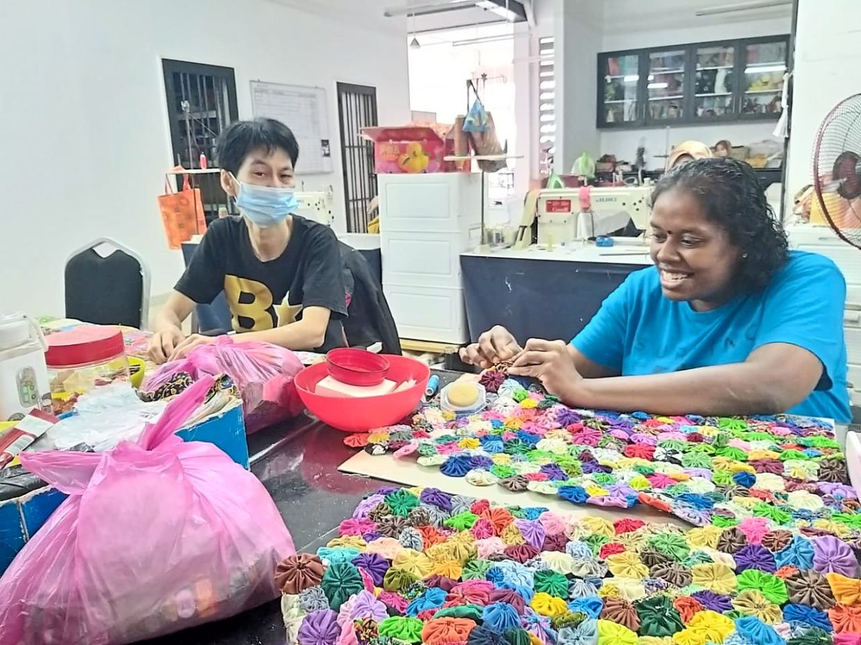 Trainees Rajeswary Kumar (right) and Then Yock Ching learning sewing techniques at Johor Area Rehabilitation Organisation.