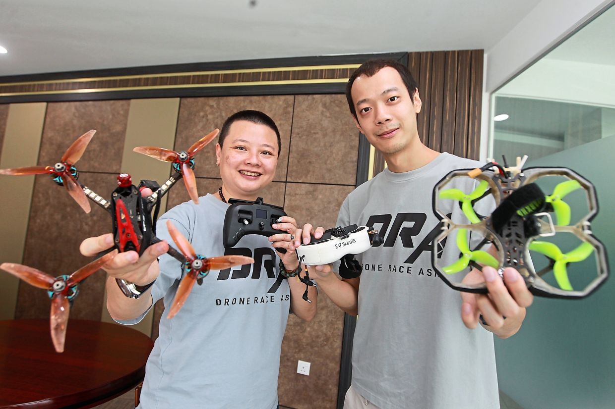 Choy (left) holds a 5in drone and Yap shows a 3in model with protective rings around the rotors. — KAMARUL ARIFFIN/The Star