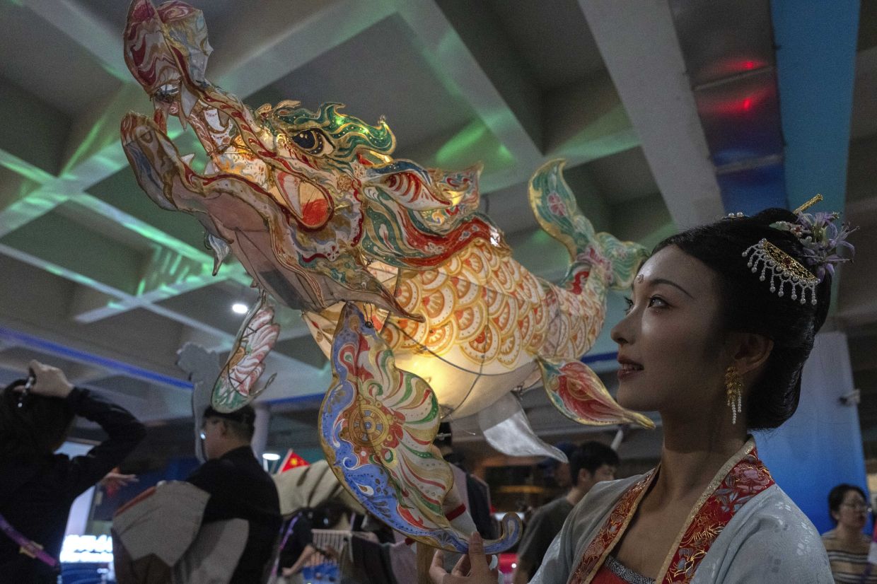 A performer wields a lantern to mark Mid-Autumn Festival at the Main Media Center during the 19th Asian Games in Hangzhou, China, Friday, Sept. 29, 2023. China won its 100th gold medal of the competion on Friday, less than a full week into the two-week event. China won 132 gold medals in the last Asian Games in Indonesia five years ago.- AP