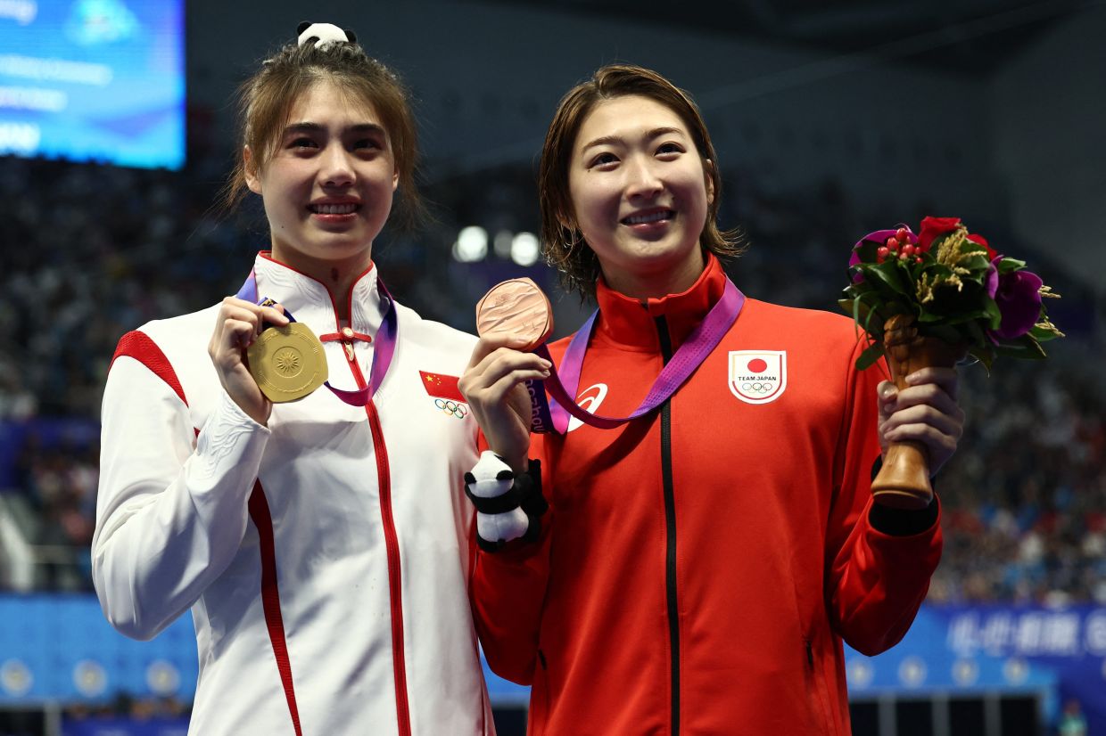 Gold medallist China's Zhang Yufei poses with bronze medallist Japan's Rikako Ikee during the medal ceremony for the Women's 50m Butterfly Asian Games event at the Sports Centre Aquatic Sports Arena in Hangzhou, China on Friday,  September 29, 2023. - Reuters