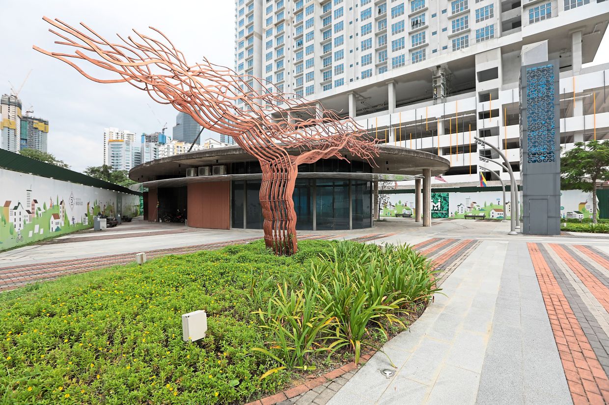 A copper tree stands in front of a newly built RoL structure opposite Pr1Ma Brickfields. 