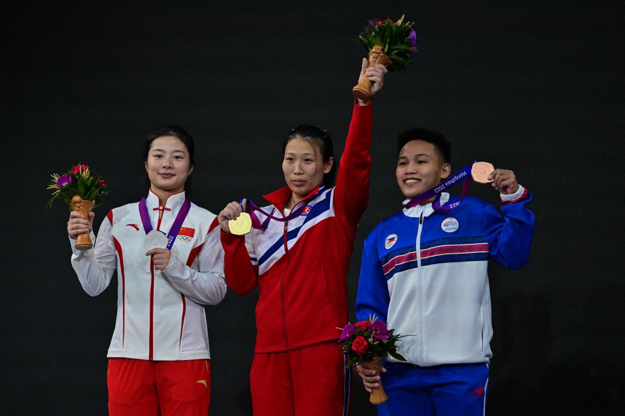 Gold medallist North Korea’s Rim Unsim (centre), silver medallist China’s Pei Xinyi (left) and bronze medallist Philippines’s Elreen Ann Ando pose during the awards ceremony after women’s 59kg group A weightlifting competition during the 2022 Asian Games in Hangzhou, in China's eastern Zhejiang province on Monday, October 2, 2023. - AFP