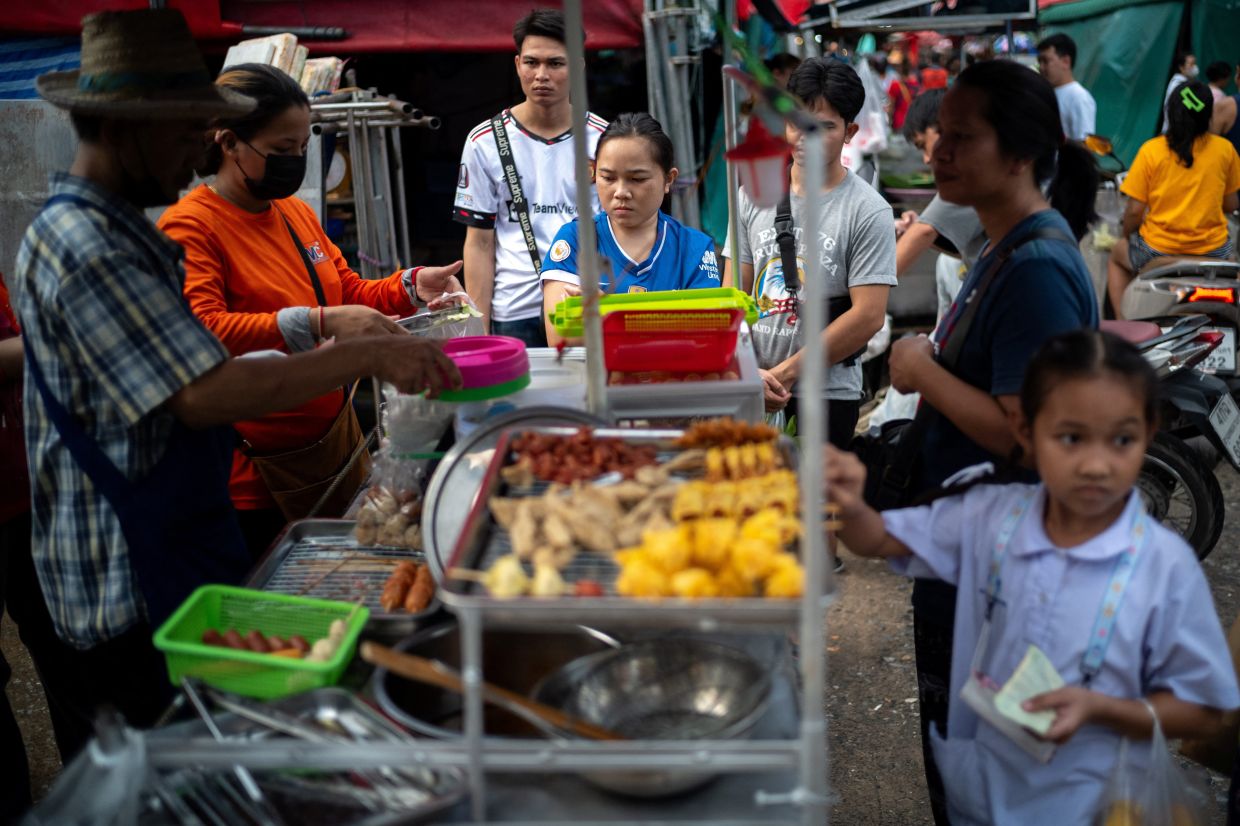 People buy street food at a market as Thailand is to inject $15.2 bln into economy next year through its digital wallet policy, in Bangkok, Thailand, on Monday, October 2, 2023. - Reuters