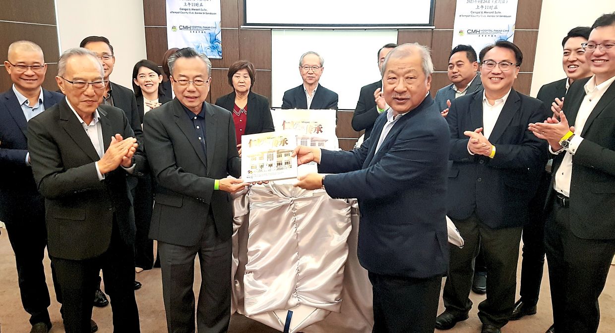 Lee (front, right) launching a coffeetable book on the hospital after the annual general meeting.