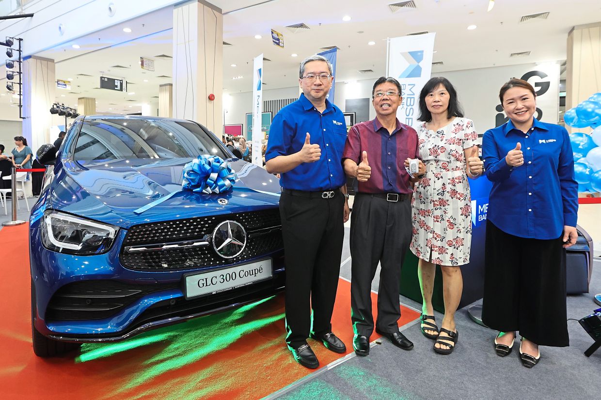 Mohd Izham Ahmad (left) with Lai Thong Fat who won the Mercedes-Benz GLC 300e Coupe and his wife Tan Boon Tieng.