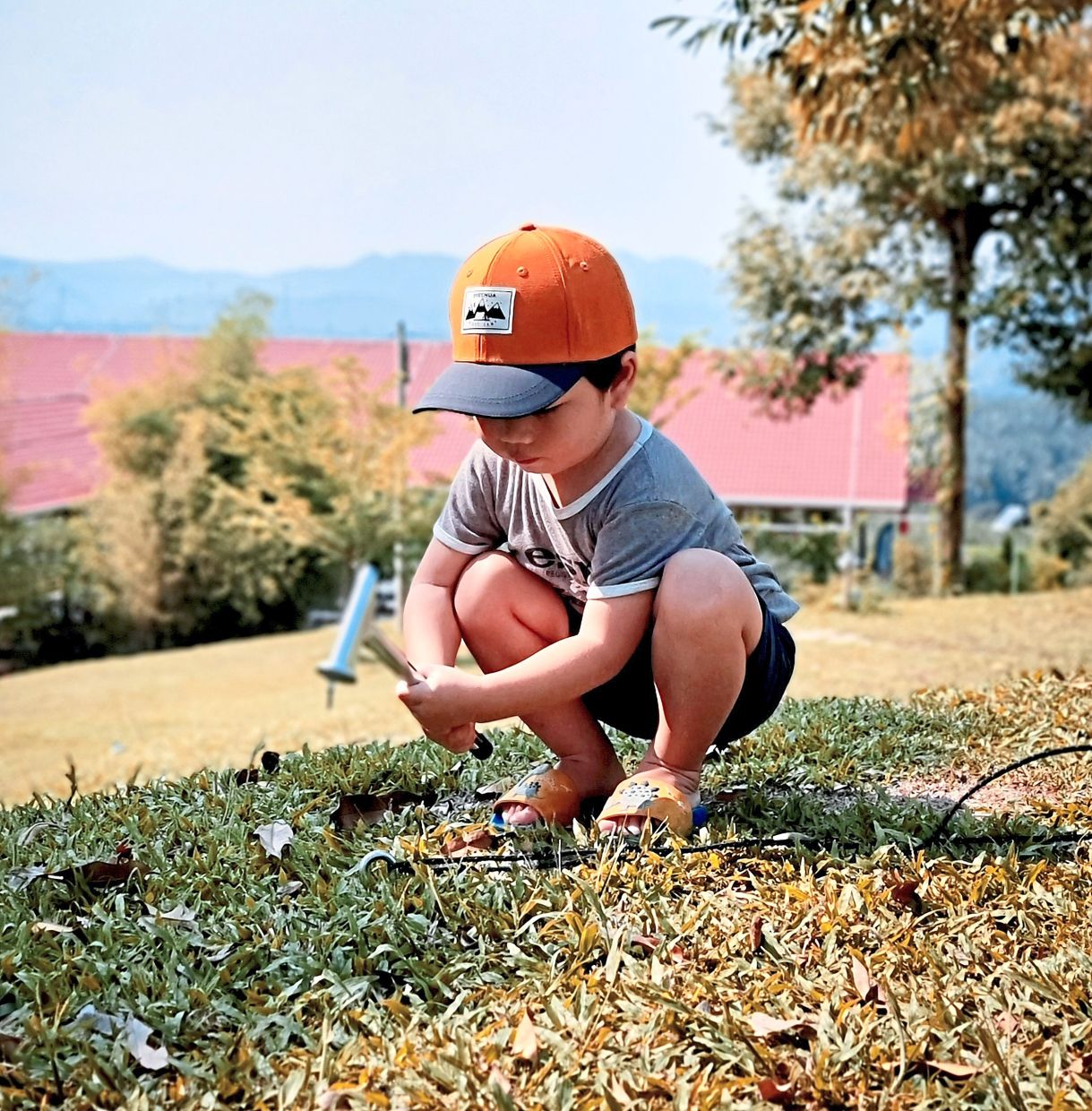 Kyren hammering a tent peg into the ground.