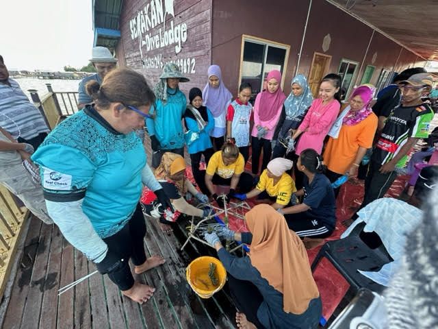 Women folk hard at work building the coral frames.