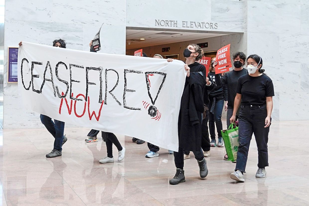 Seeking peace: Anti-war activists calling for ceasefire at the Hart Senate Office building in the US Capitol, Washington DC. — AP