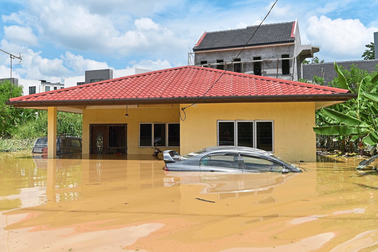 Water everywhere: Cars and a house partly submerged in floodwaters after a heavy downpour in Kampung Bangi Tambahan on Nov 5. — Bernama