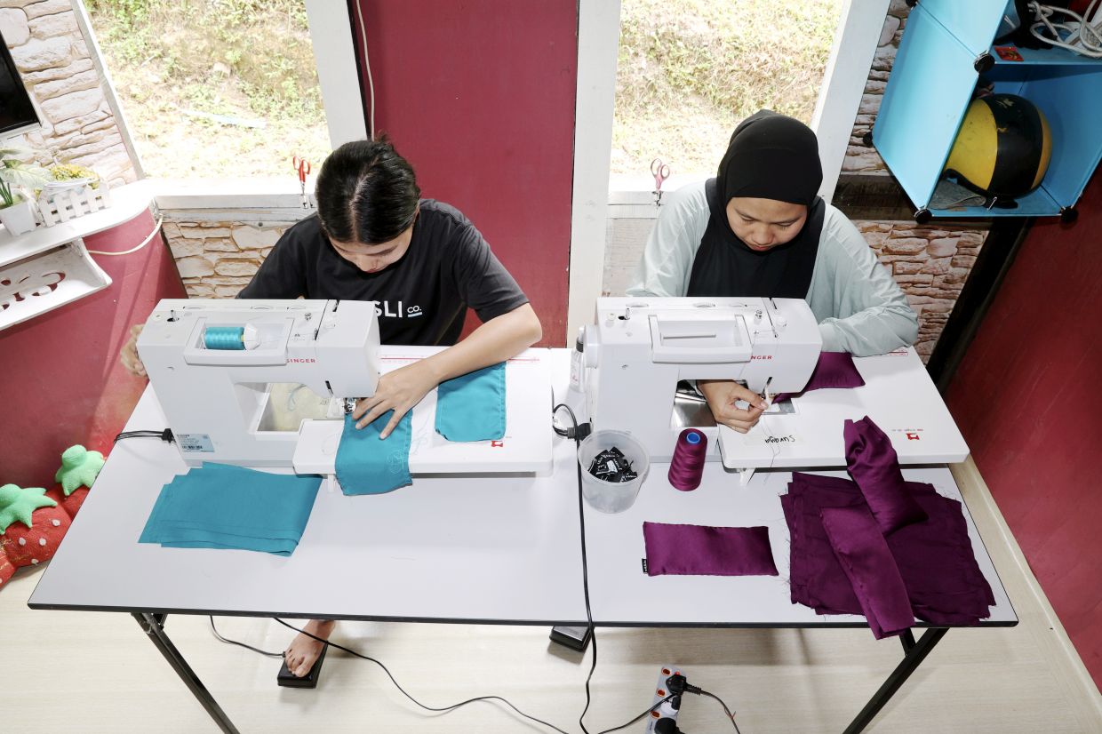 Suraya (right) and her friend, Antik As, working on sewing the lavender eye pillow under The Asli Co. social enterprise initiative.