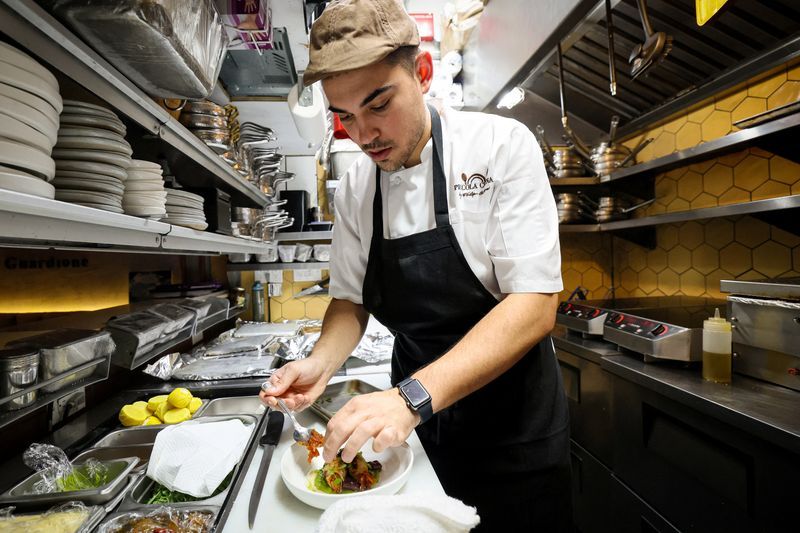 Chef Davide Sanna works in the kitchen of Piccola Cucina in the SoHo area of New York City U.S. November 22 2023.  REUTERSBrendan McDermid