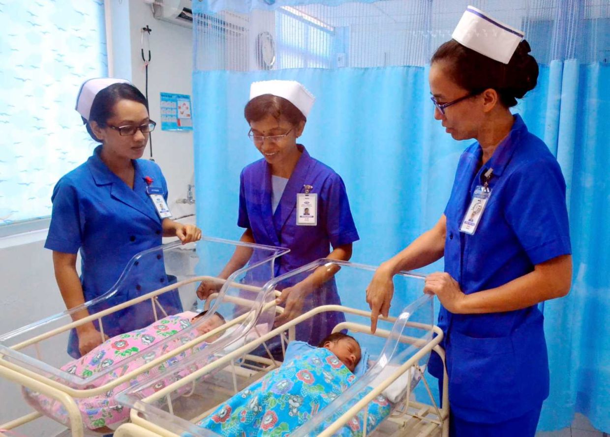 Perak Community Specialist Hospital ward sisters and widwives looking at dragon-year babies in this photo dated Nov 25, 2012.