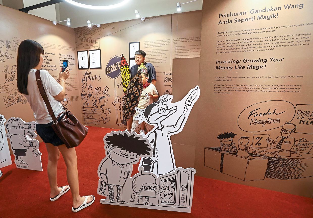 Visitors taking photos of a display at the Financial LATeracy exhibition.