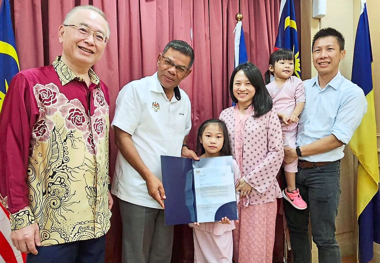 Delight: Mia receiving her Malaysian citizenship certificate from Saifuddin Nasution as (from left) Dr Wee, Esther and Herrizon holding his youngest daughter look on. — Photo courtesy of Dr Wee’s Facebook page