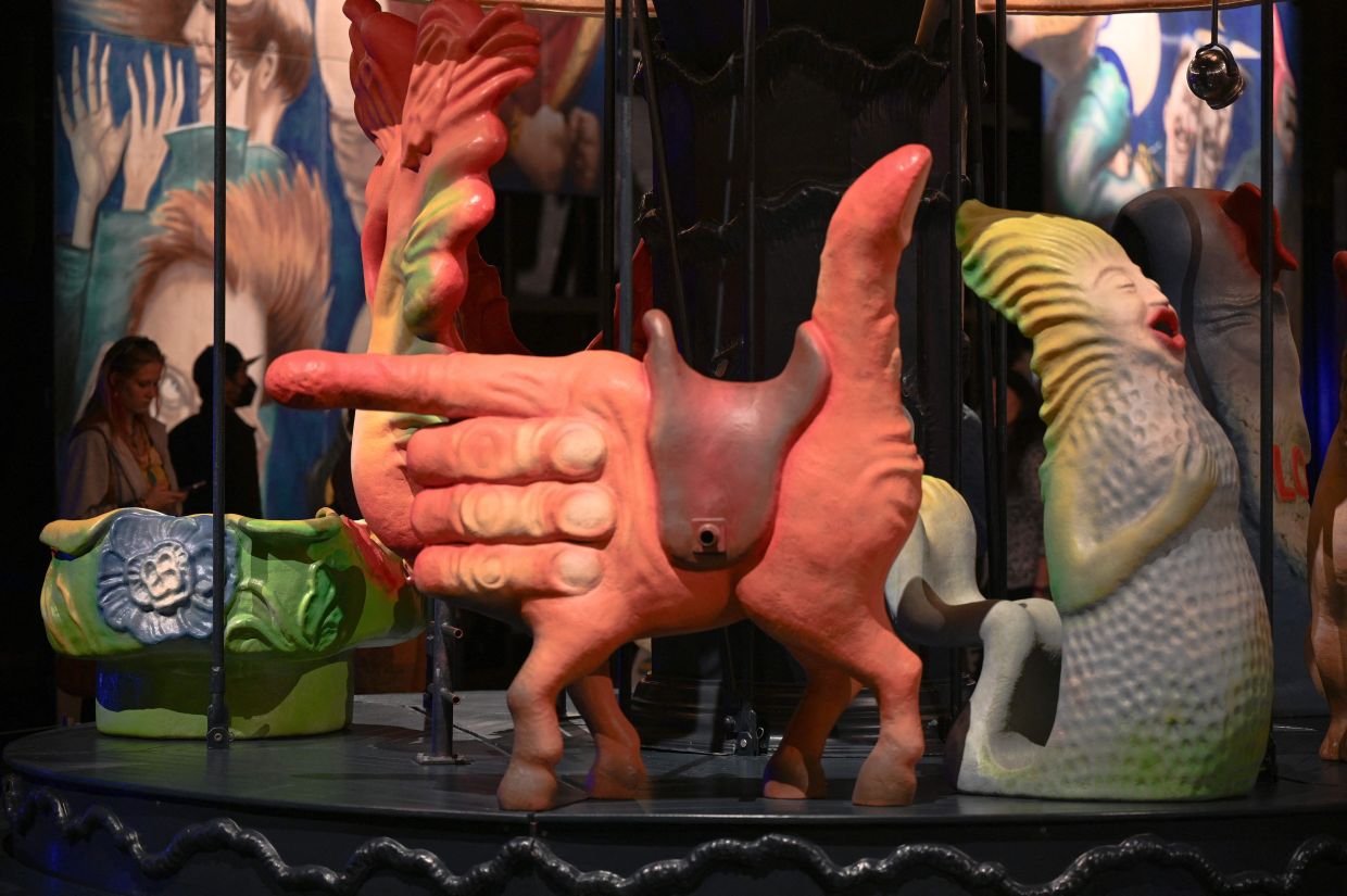 Visitors experience the fantastical carousel by artist Arik Brauer featuring eight different characters, among them a butterfly, a she-wolf, a mermaid, and hand-horse that double as seats, at Luna Luna: Forgotten Fantasy in Los Angeles. Photo: AFP