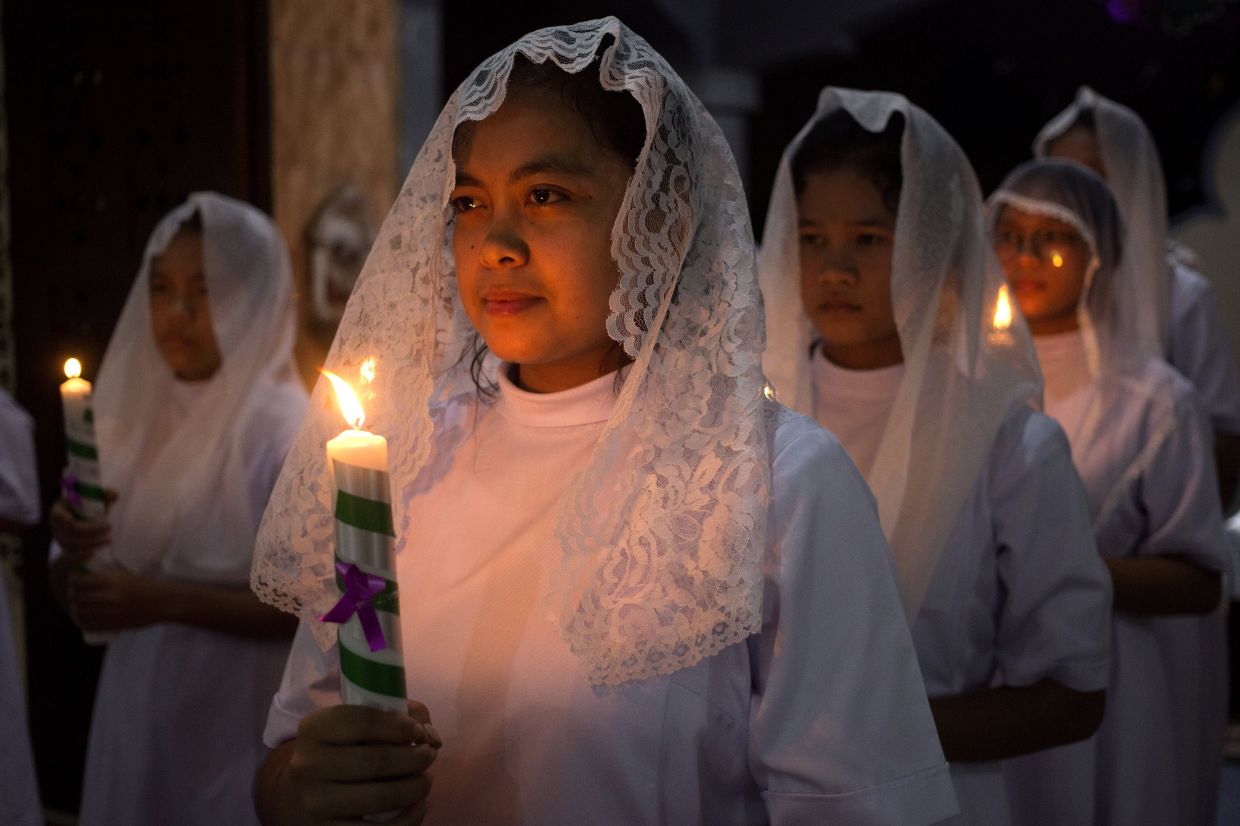 Nuns hold candles during the Christmas Eve mass at Graha Maria Annai Velangkanni Church in Medan, North Sumatra, Indonesia. - AP