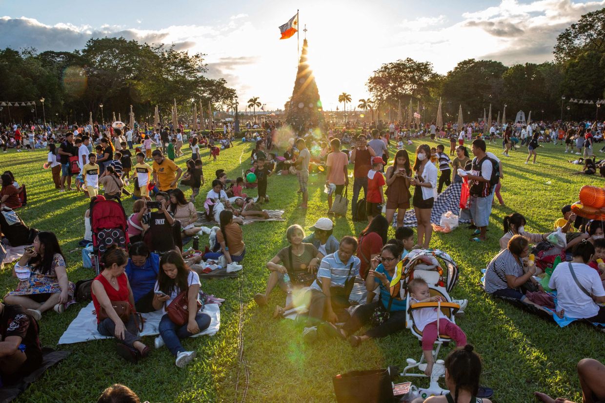 People gather at Rizal Park on Christmas day in Manila on Christmas Day, Monday, December 25, 2023. - AFP