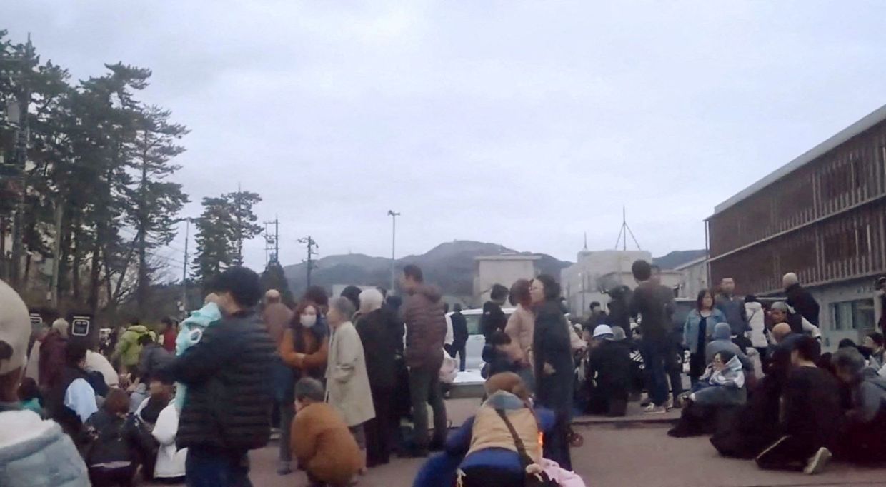 People evacuate to higher ground at a parking space of a junior high school after a tsunami warning issued caused by an earthquake in Wajima, Ishikawa prefecture, Japan, Sunday, January 1, 2024, in this still image from a video released by Kyodo via REUTERS.