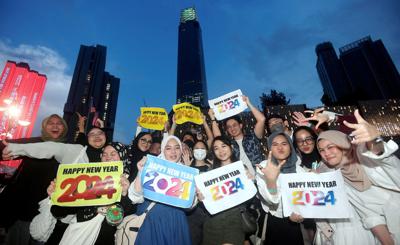 Youth holding placards during the New Year Countdown concert  at The Exchange TRX in Kuala Lumpur. — AZHAR MAHFOF/The Star