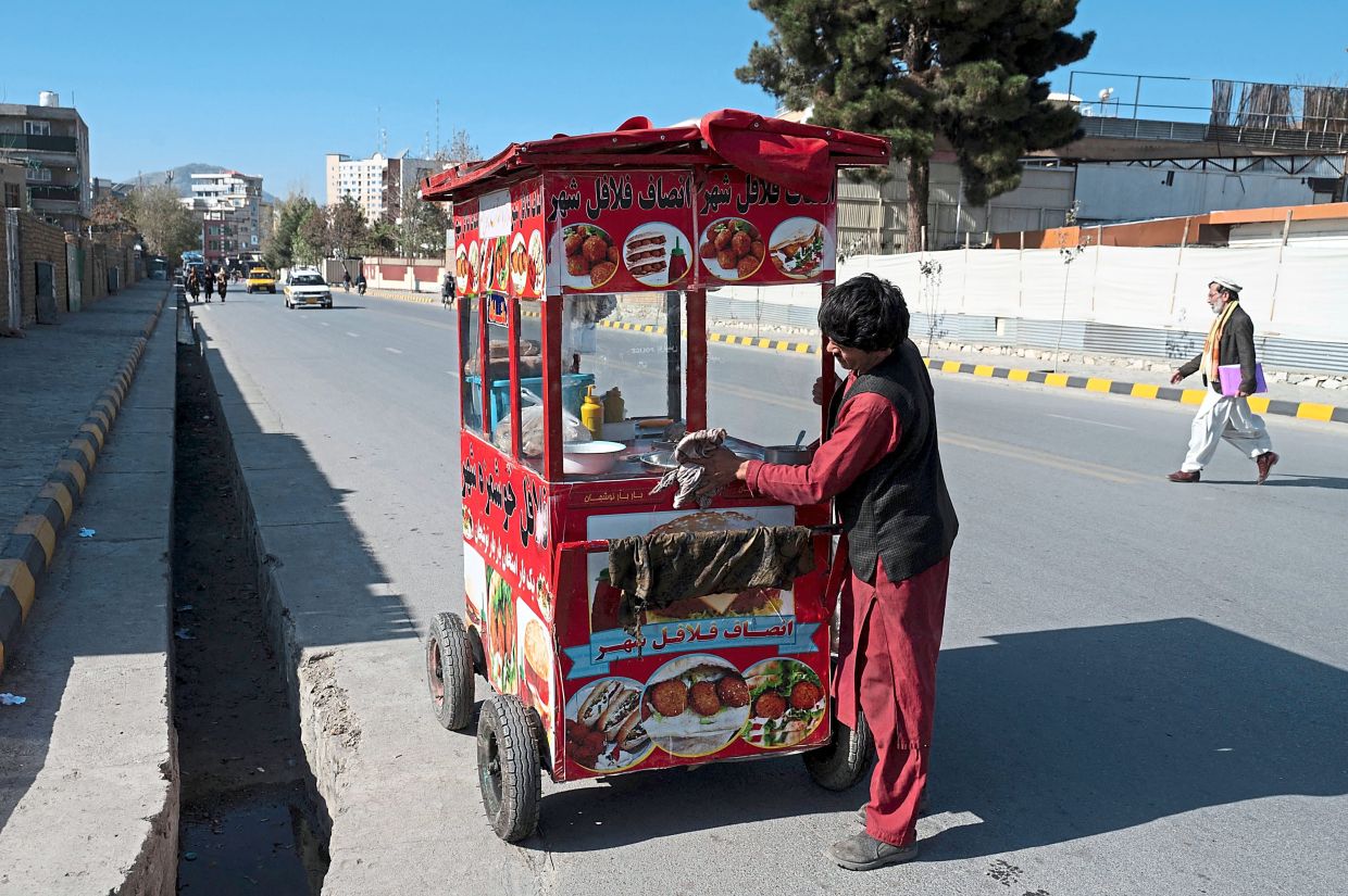 An Afghan falafel vendor cleaning his cart as he waits for customers along a road in the Sherpur area in Kabul. — AFP