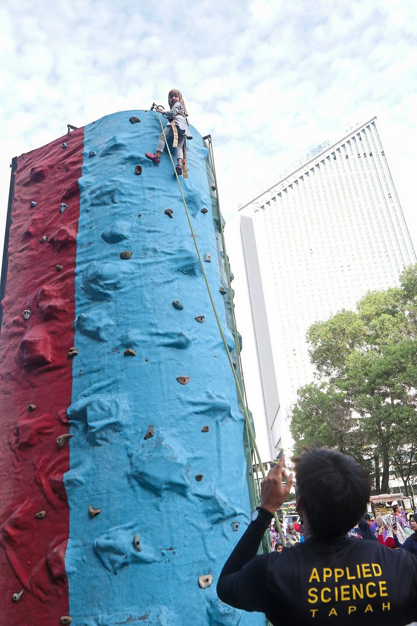 Ainnur Mardhiyah Muhammad Muaaz, six, taking part in the wall climbing activity.