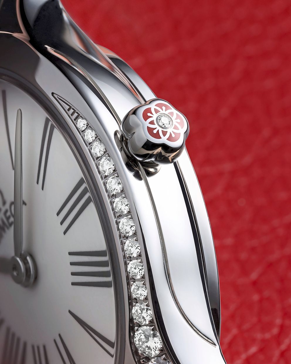The crown engraved with an Omega flower in red hybrid ceramic and set with a single diamond.