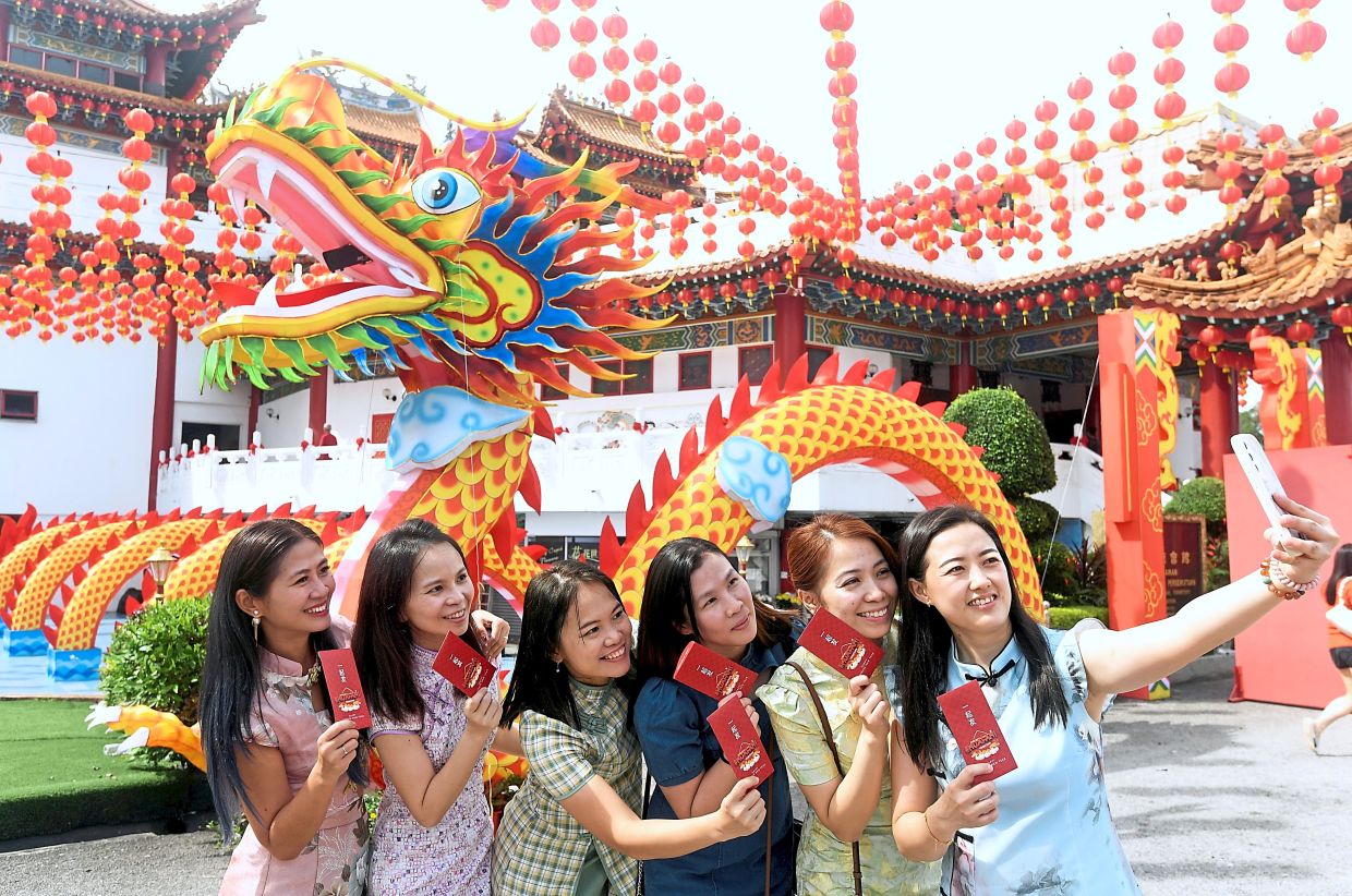 Dragon backdrop and ang pow make up the essentials for this group photo at Thean Hou Temple.