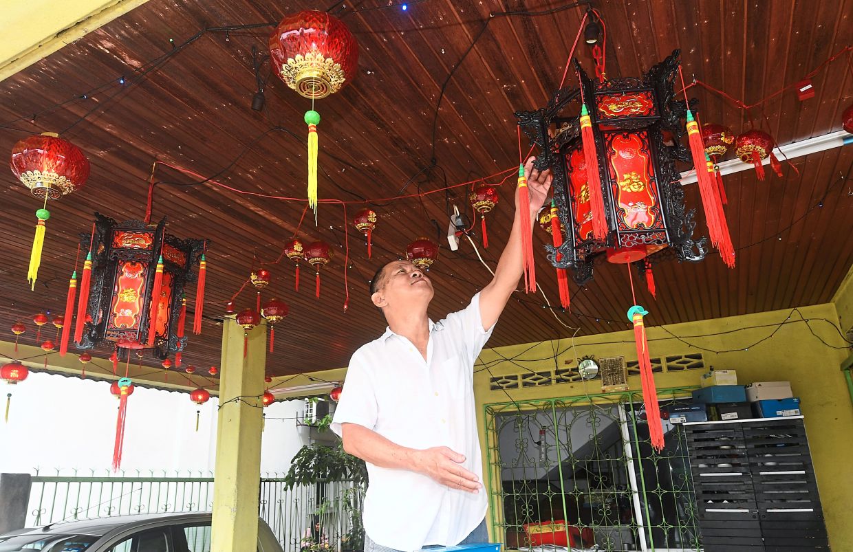 Yip ensuring the porch of his family house is lit up for CNY.