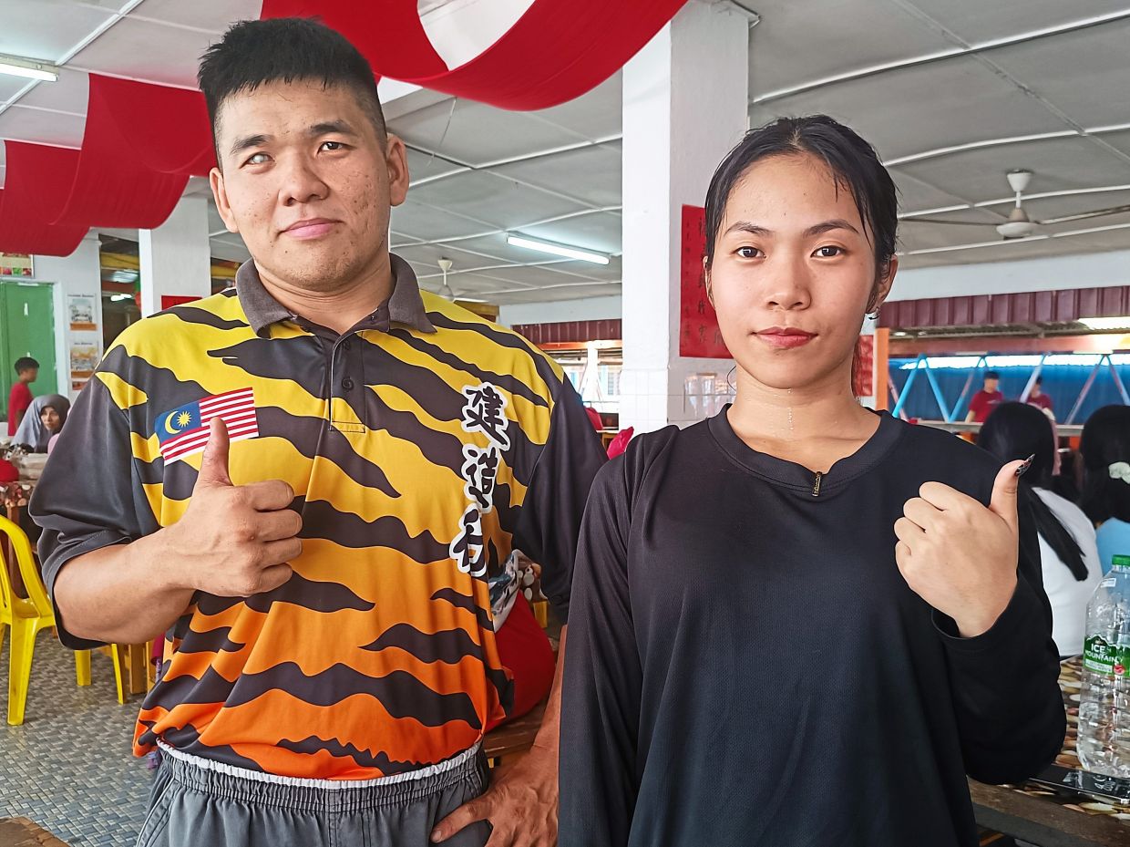 Chong (right) and Chan who perform as the head and tail of the lion. (Right) 