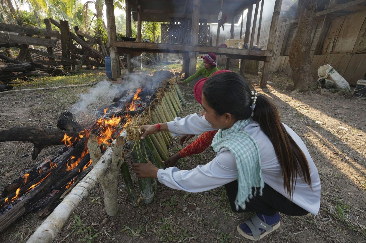 Farmers burned sticky rice in bamboos are called kralan for a rite in a post rice harvest festival in Tang Bampong near Aoral mountain in Kampong Speu province, southwest of Phnom Penh, Cambodia, Friday, Feb. 16, 2024. - AP