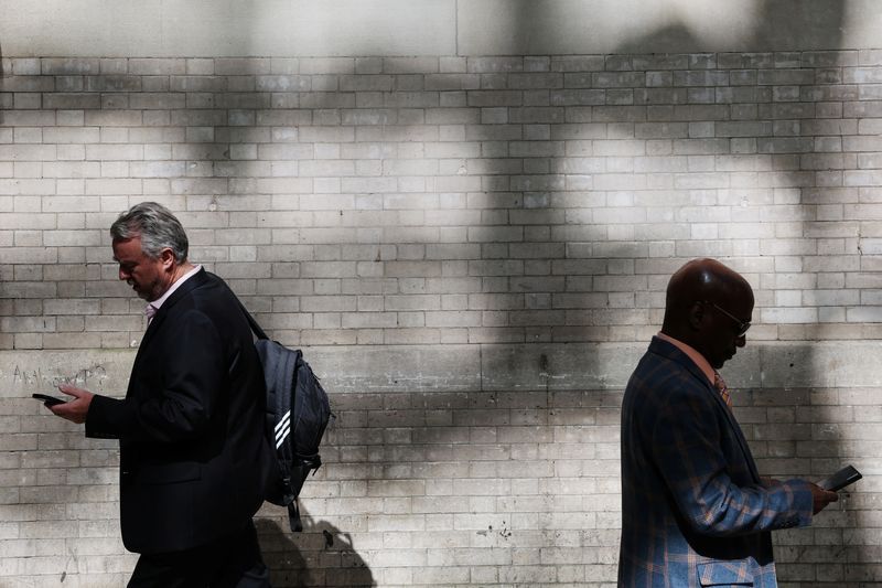 Men walk looking at their smartphones in the Midtown area of New York City U.S. October 5 2023.  REUTERSShannon Stapleton