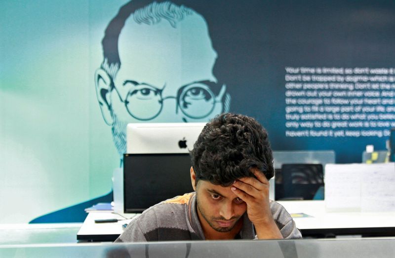 FILE PHOTO An employee works on a computer terminal against the backdrop of a picture of late Apple co-founder Steve Jobs at the Start-up Village in Kinfra High Tech Park in the southern Indian city of Kochi October 13 2012. REUTERSSivaram VFile Photo