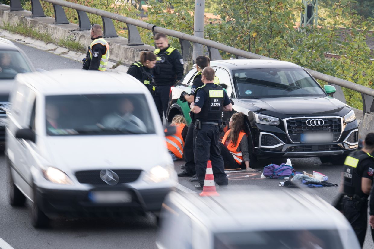 Cars drive through a lane cleared by the police during a road blockade organised by climate protection group Letzte Generation on a German motorway. Photo: Sebastian Christoph Gollnow/dpa 