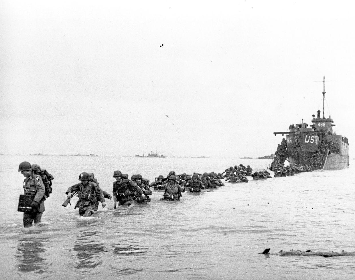 United States reinforcements wade through the surf from a landing craft in the days following D-Day and the Allied invasion of Nazi-occupied France at Normandy in June 1944 during World War II. — AP