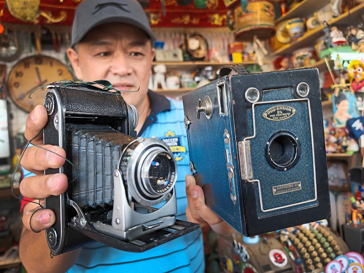 Lim with two antique cameras.