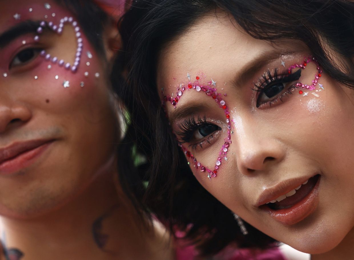 Taylor Swift fans Quang, 23, from Vietnam and Qin Xian, 23, from Chongqing, China, show their make-up inspired by Swift's Lover era, ahead of her concert in Singapore, on Friday, March 8, 2024. - Reuters