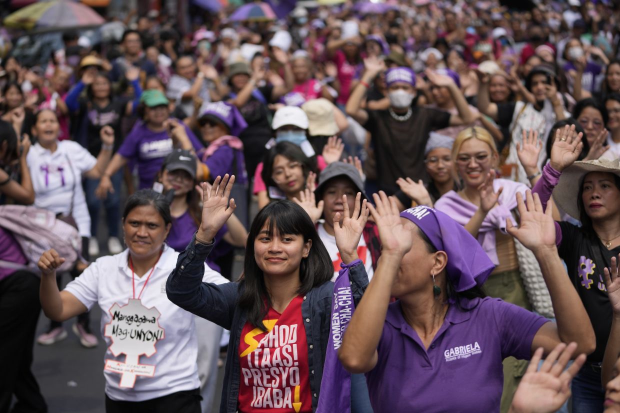 Activists dance during an International Women's Day protest in Manila, Philippines on Friday, March 8, 2024. - AP