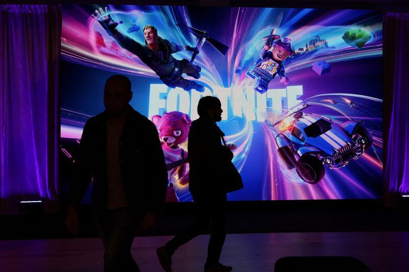 FILE PHOTO People in silhouette walk by a Fortnite gaming digital monitor during an event in New York City U.S. December 4 2023.  REUTERSShannon StapletonFile Photo