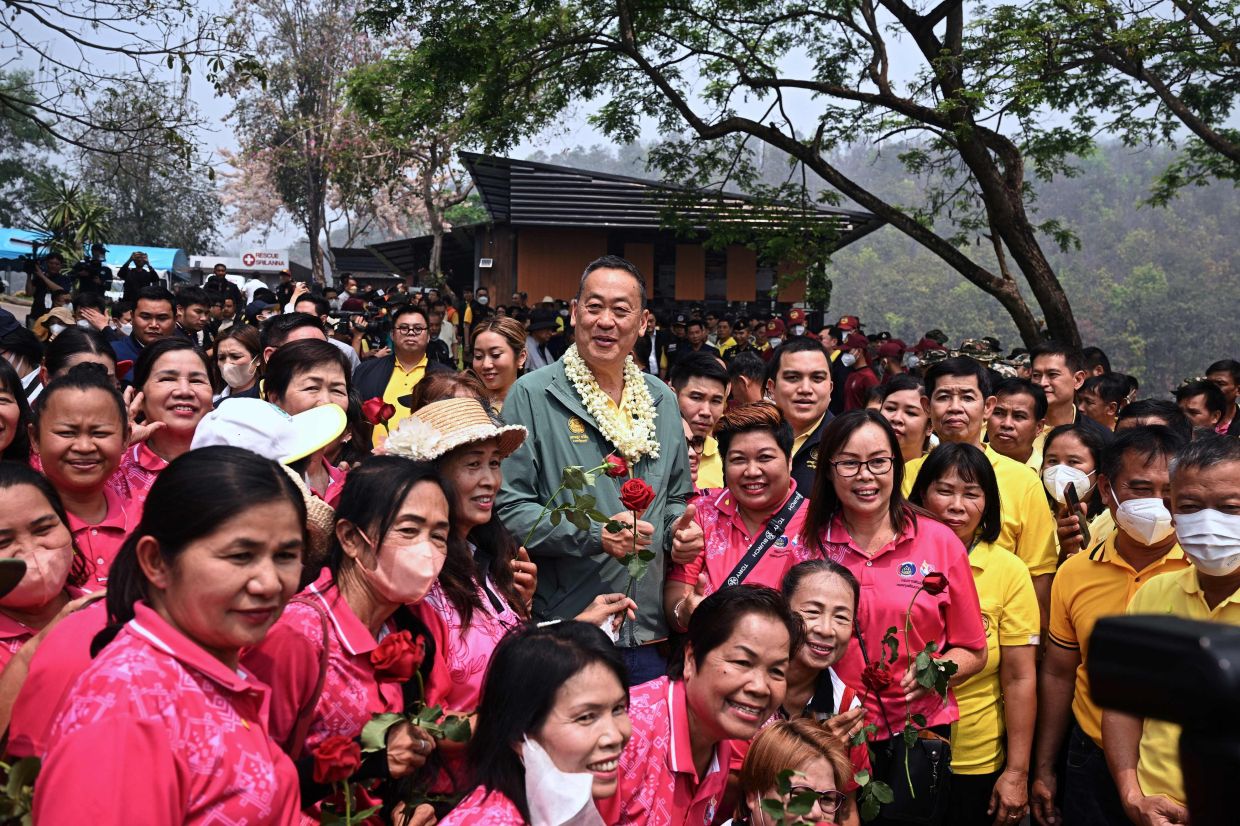 Thailand's Prime Minister Srettha Thavisin (centre) poses for photos with workers from the Department of Community Development at the Srilanna National Park headquarters, as he attends meetings to address air pollution issues, in the northern Thai province of Chiang Mai on Saturday, March 16, 2024. - AFP