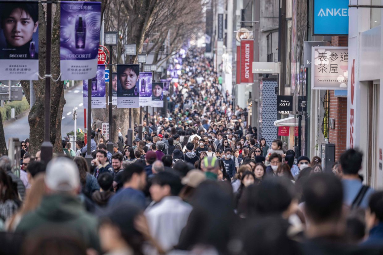 People walk through Omotesando shopping street in Tokyo on Sunday, March 17, 2024. - AFP