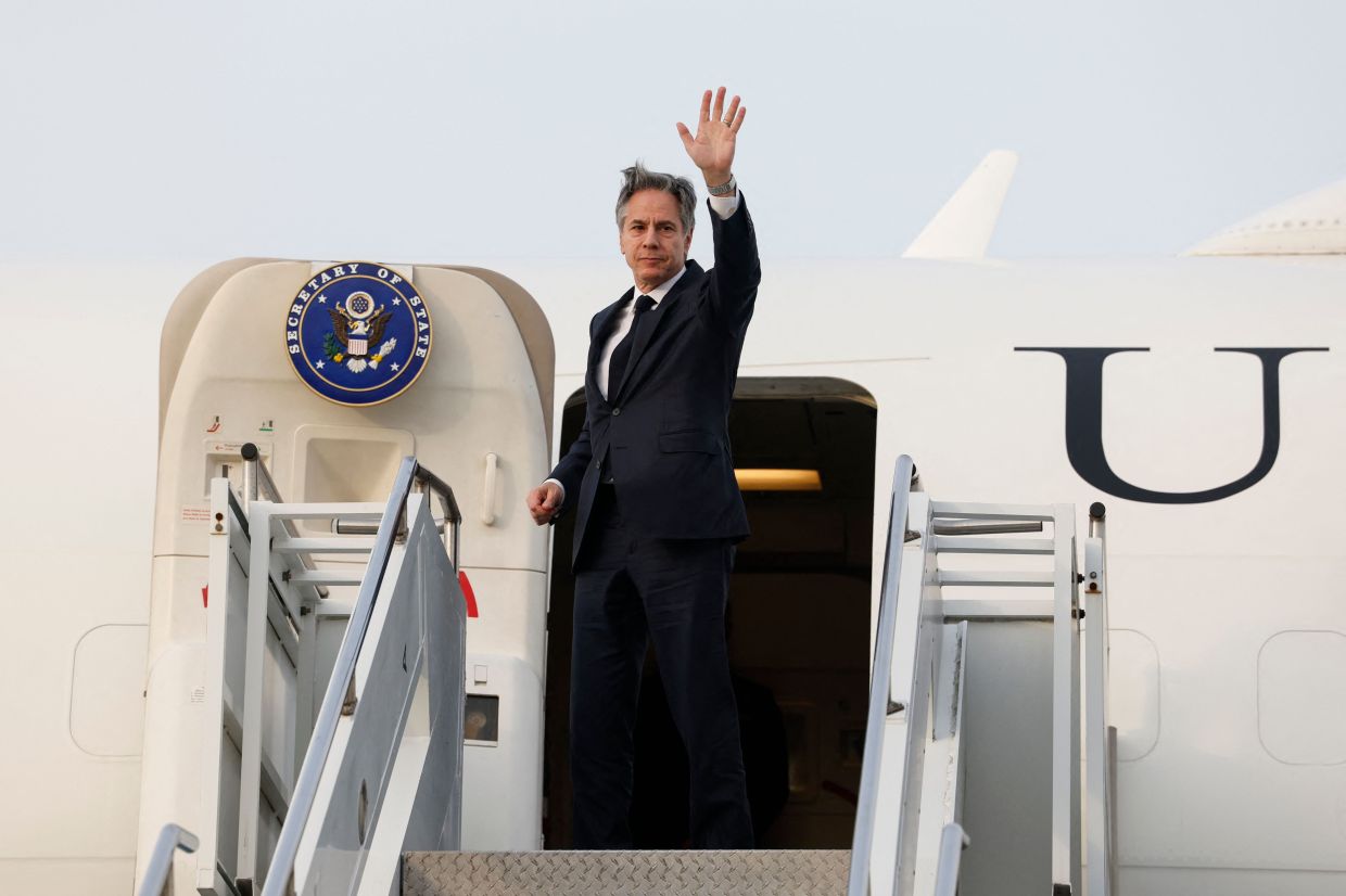 US Secretary of State Antony Blinken waves as he boards an airplane to travel to the Philippines from Osan Air Base in Pyeongtaek on Monday, March 18, 2024. - AFP