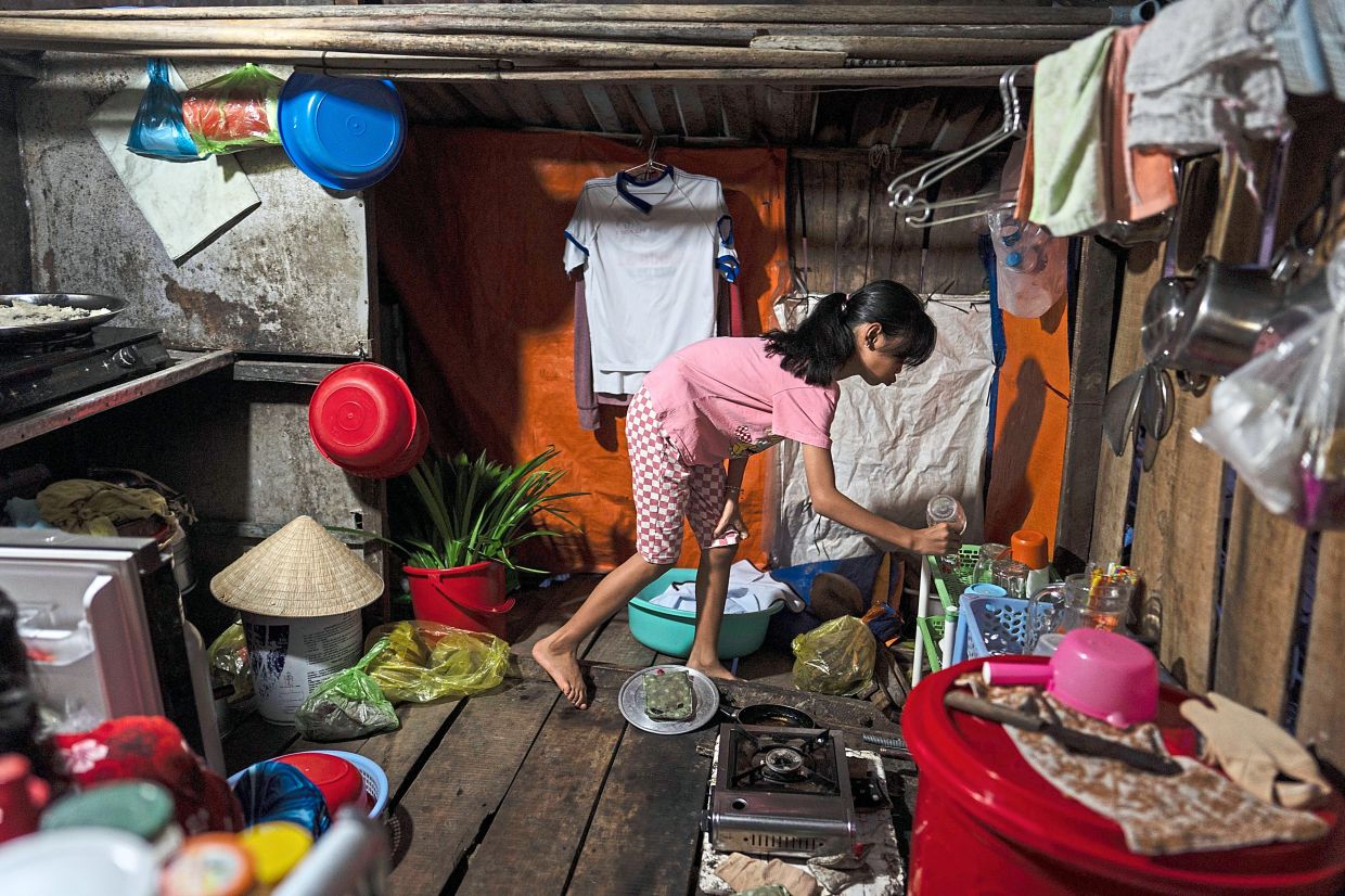 Tran grabbing a cup in the kitchen in Can Tho. — AP